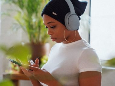 woman in white crew neck t-shirt holding smartphone