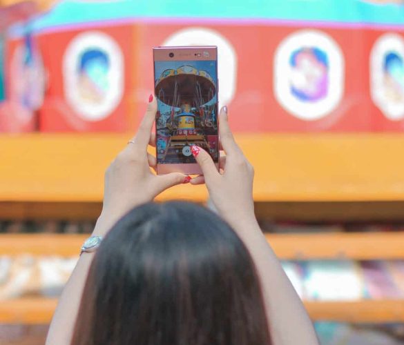 woman holding iphone 6 taking photo of yellow and red building
