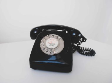 black rotary phone on white surface
