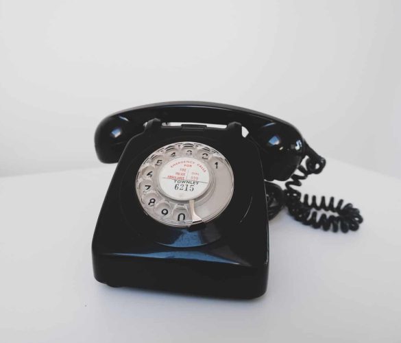 black rotary phone on white surface